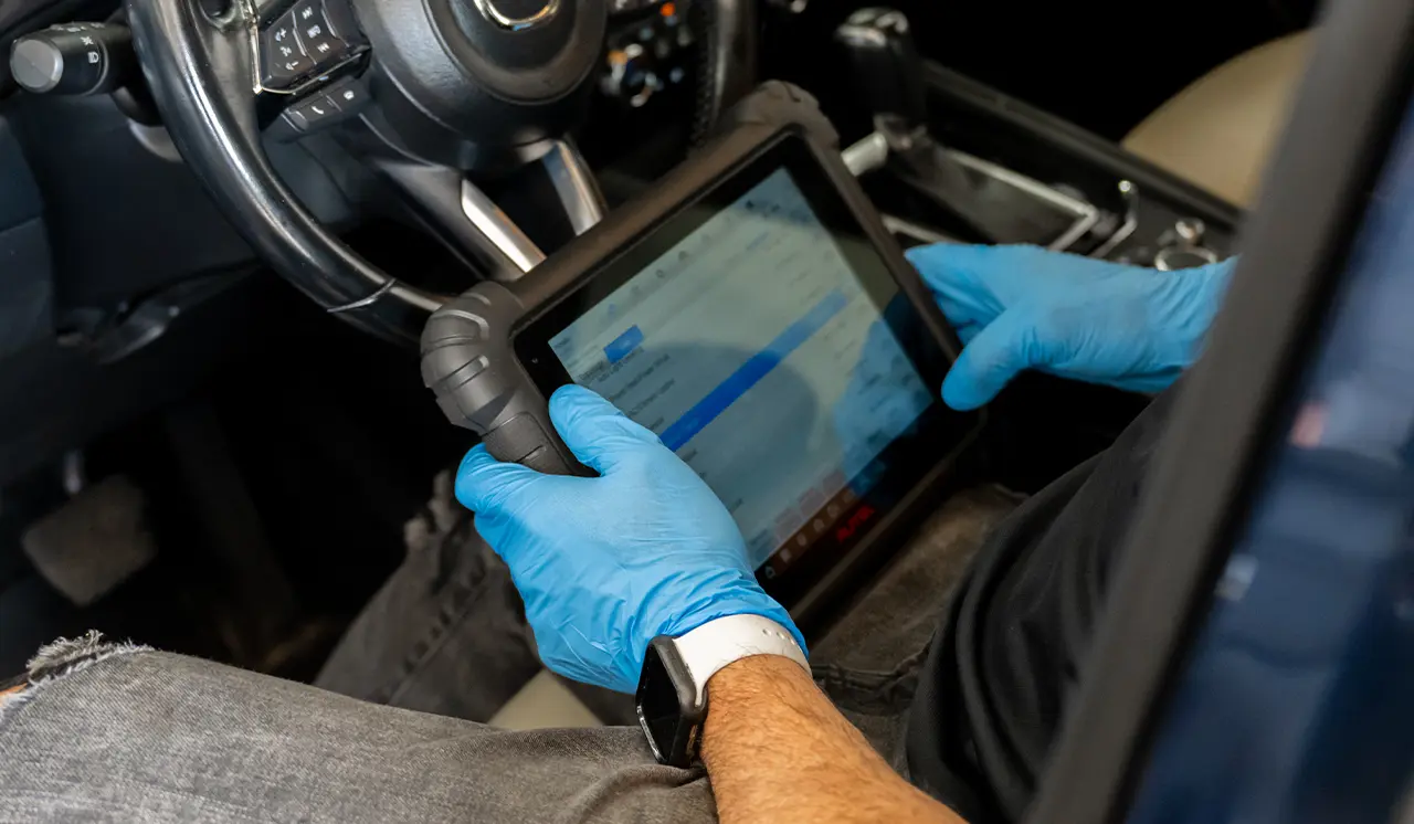 Technician with ipad in car dynamic calibration