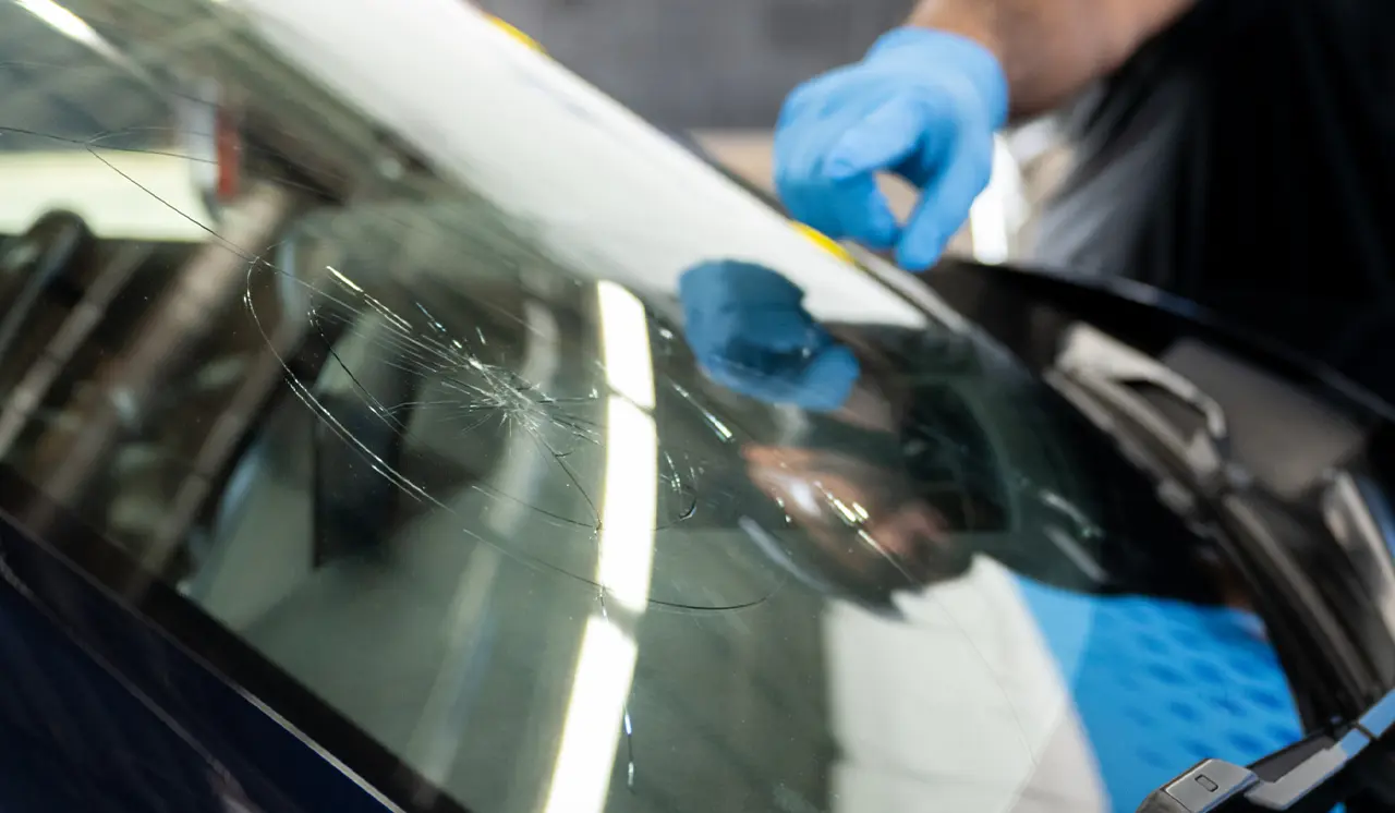Technician pointing to crack in windshield.