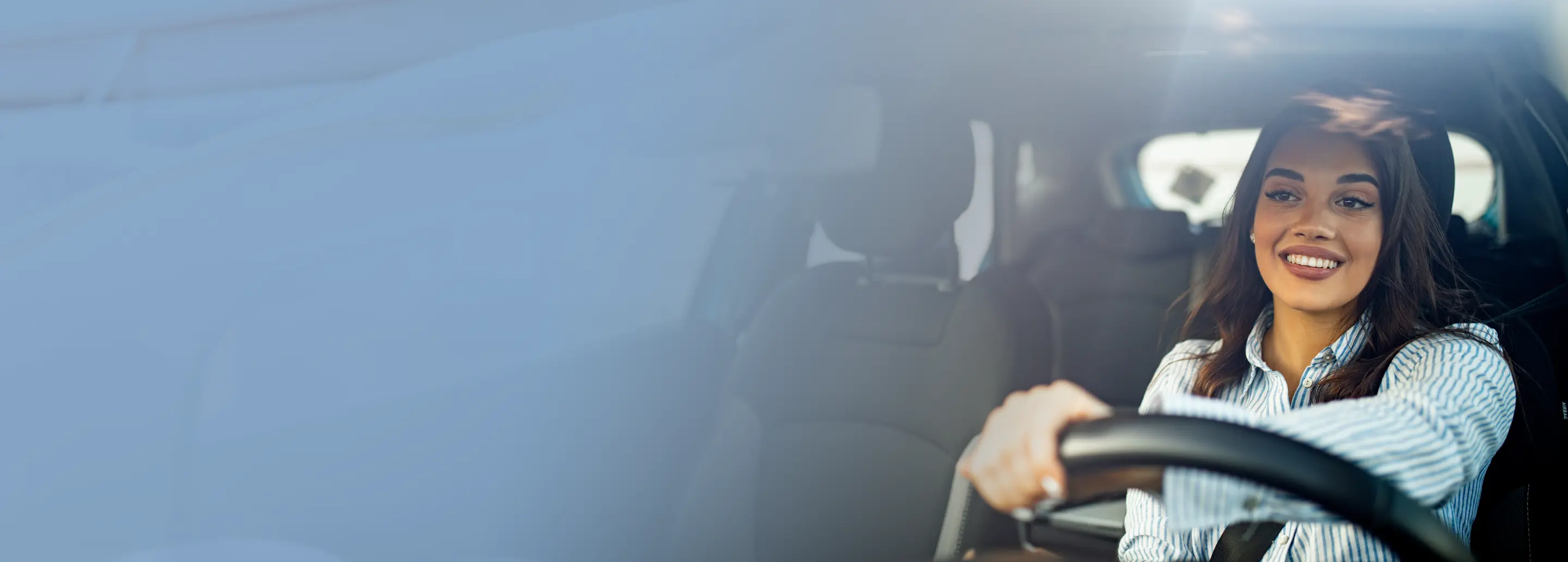 Smiling woman driving vehicle.