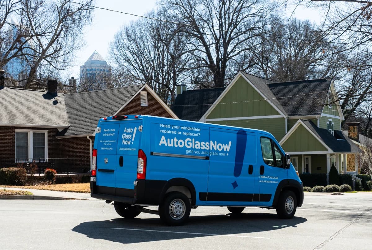 Auto Glass Now mobile service van on street in front of houses