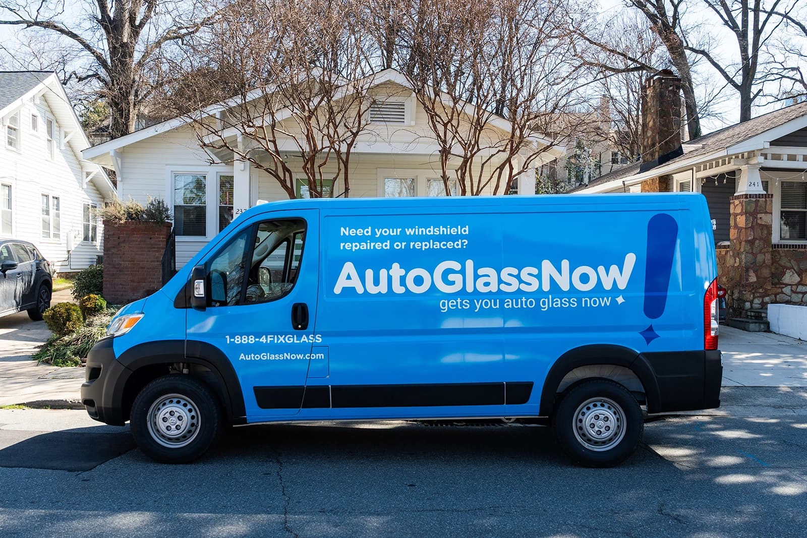 Mobile repair van driving parked in front of house.